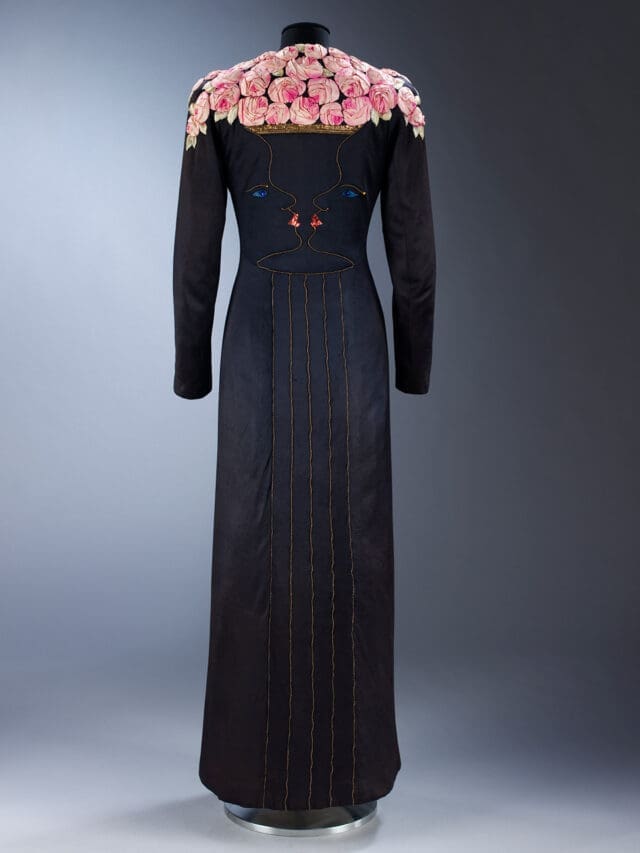Ankle-length coat of black silk jersey with facial profiles forming a rose-filled vase, Elsa Schiaparelli, Jean Cocteau and Lesage